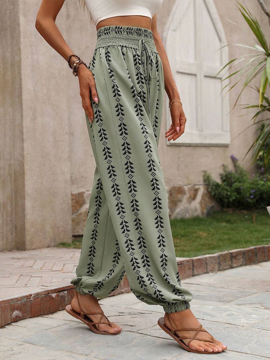 Tied printed high waist pants in green with black pattern, 100% polyester, stylish and comfortable fit.