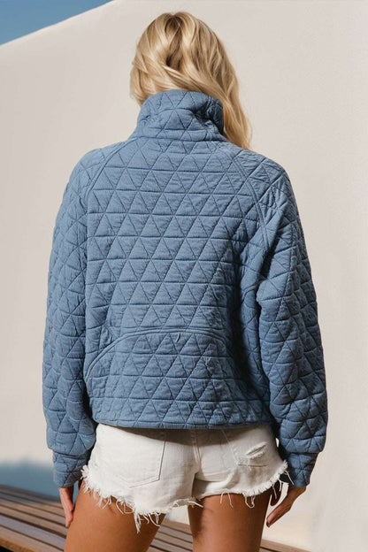 Blue half zip long sleeve quilted sweatshirt with pocket, back view.