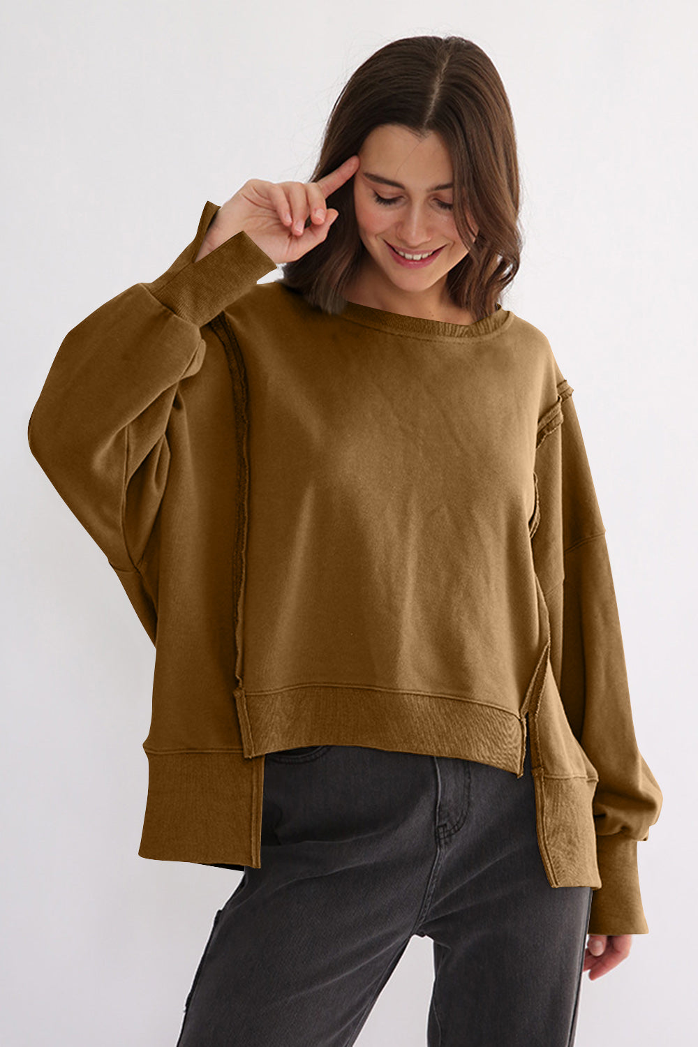 Exposed seam high-low long sleeve sweatshirt in brown, featuring a slit design and slightly stretchy, 100% cotton fabric.