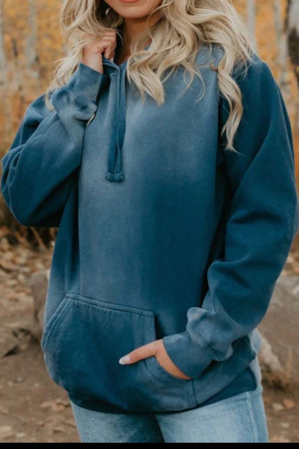 Drawstring pocketed dropped shoulder hoodie in blue, worn outdoors.