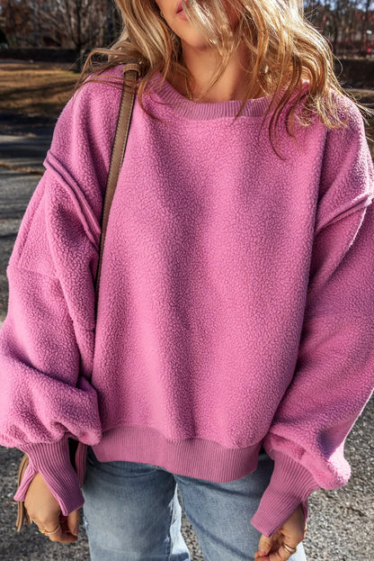 Slit Round Neck Long Sleeve Sweatshirt in pink with exposed seam and high-low design.