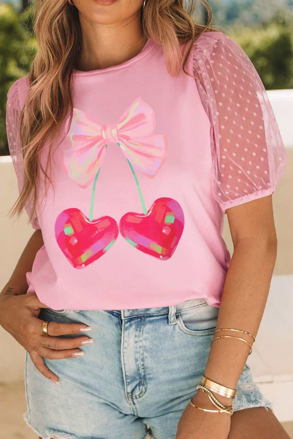 Pink semi-sheer cherry hearts graphic T-shirt with polka dot sleeves.