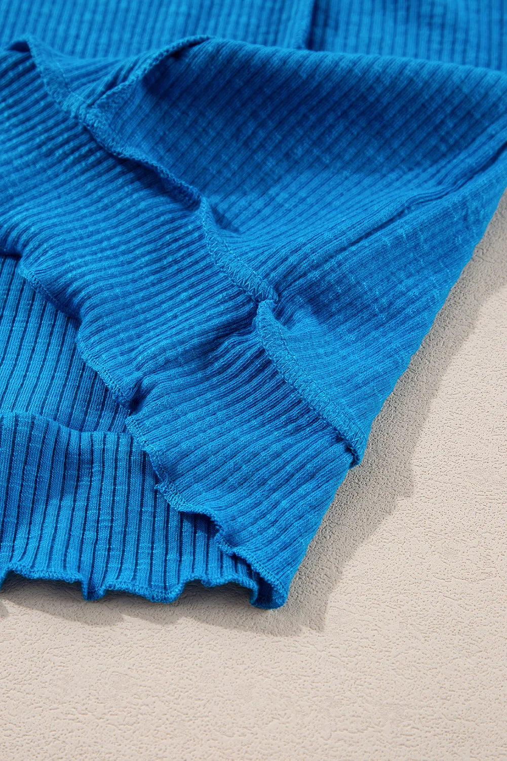 Blue Exposed Seam Notched Long Sleeve Blouse showing ribbed texture and seam details.