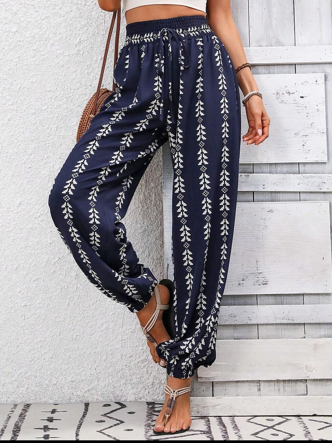 Tied printed high waist pants in navy with white pattern, polyester material.