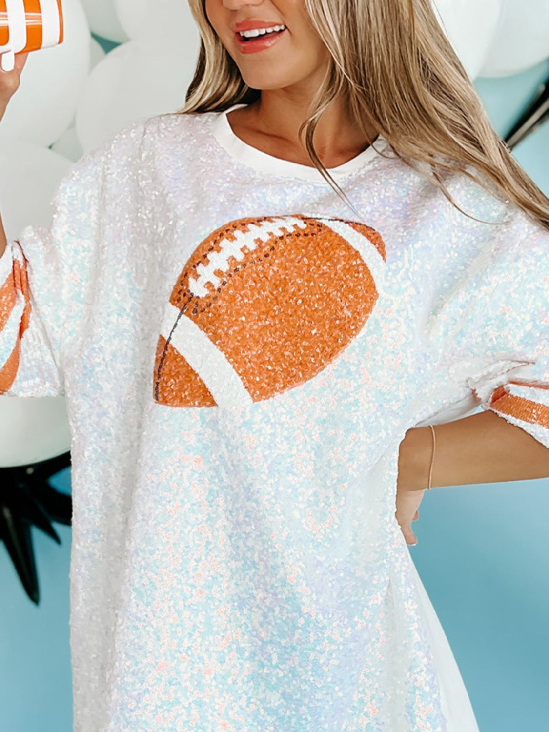 Sequin football oversized T-shirt with orange football graphic, made of 95% polyester and 5% cotton.