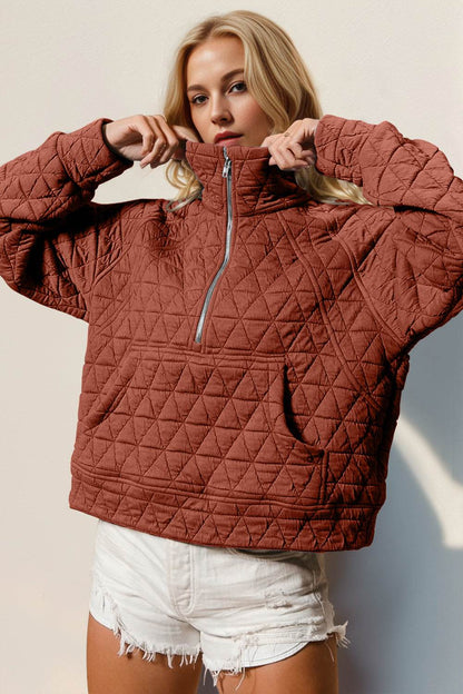 Half zip long sleeve quilted sweatshirt with pocket, slightly stretchy, in rust color.