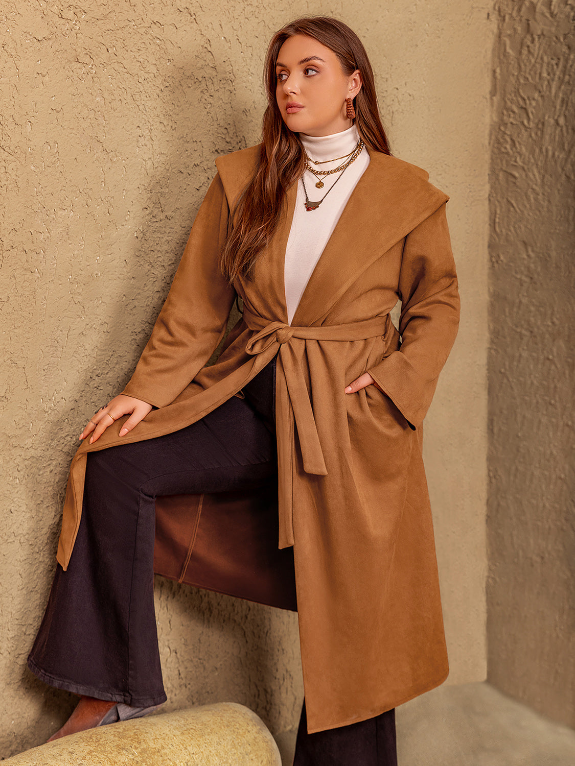 Plus size tied long sleeve hooded coat with pockets in brown, worn by a model indoors.