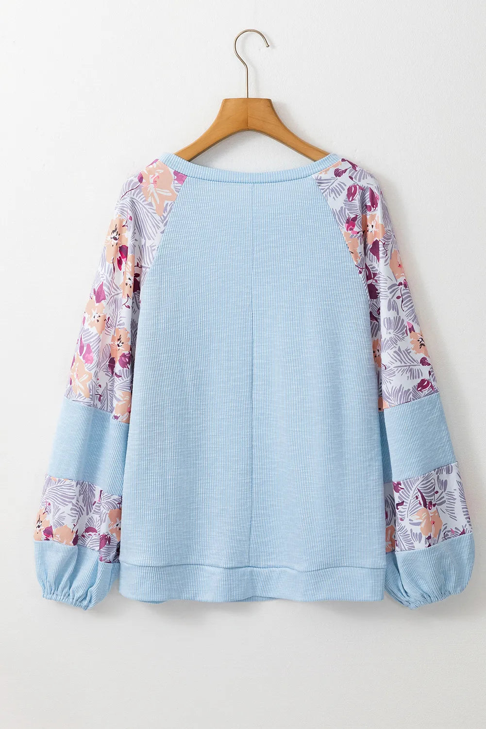 Printed round neck balloon sleeve blouse with colorful patterns and loose fit design. 