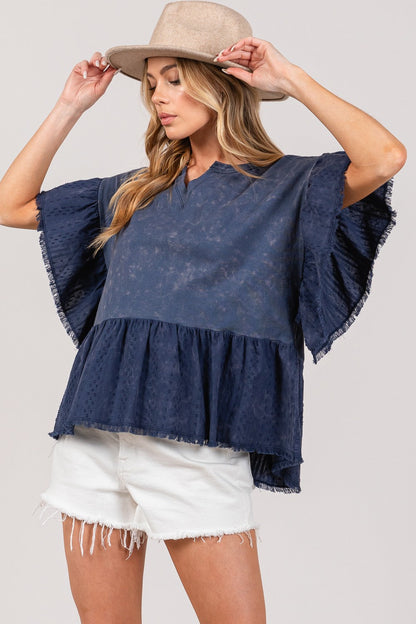 Ruffle sleeve washed short sleeve blouse in navy with frayed hem, paired with white shorts and a beige hat.