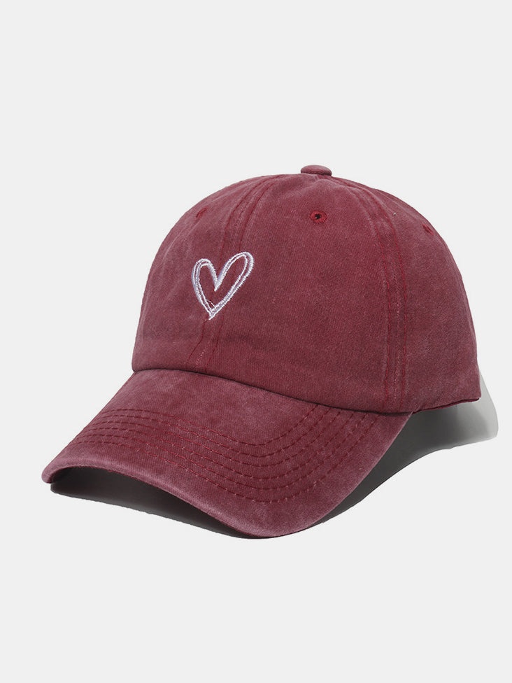 Pink washed cotton baseball cap with embroidered heart design.