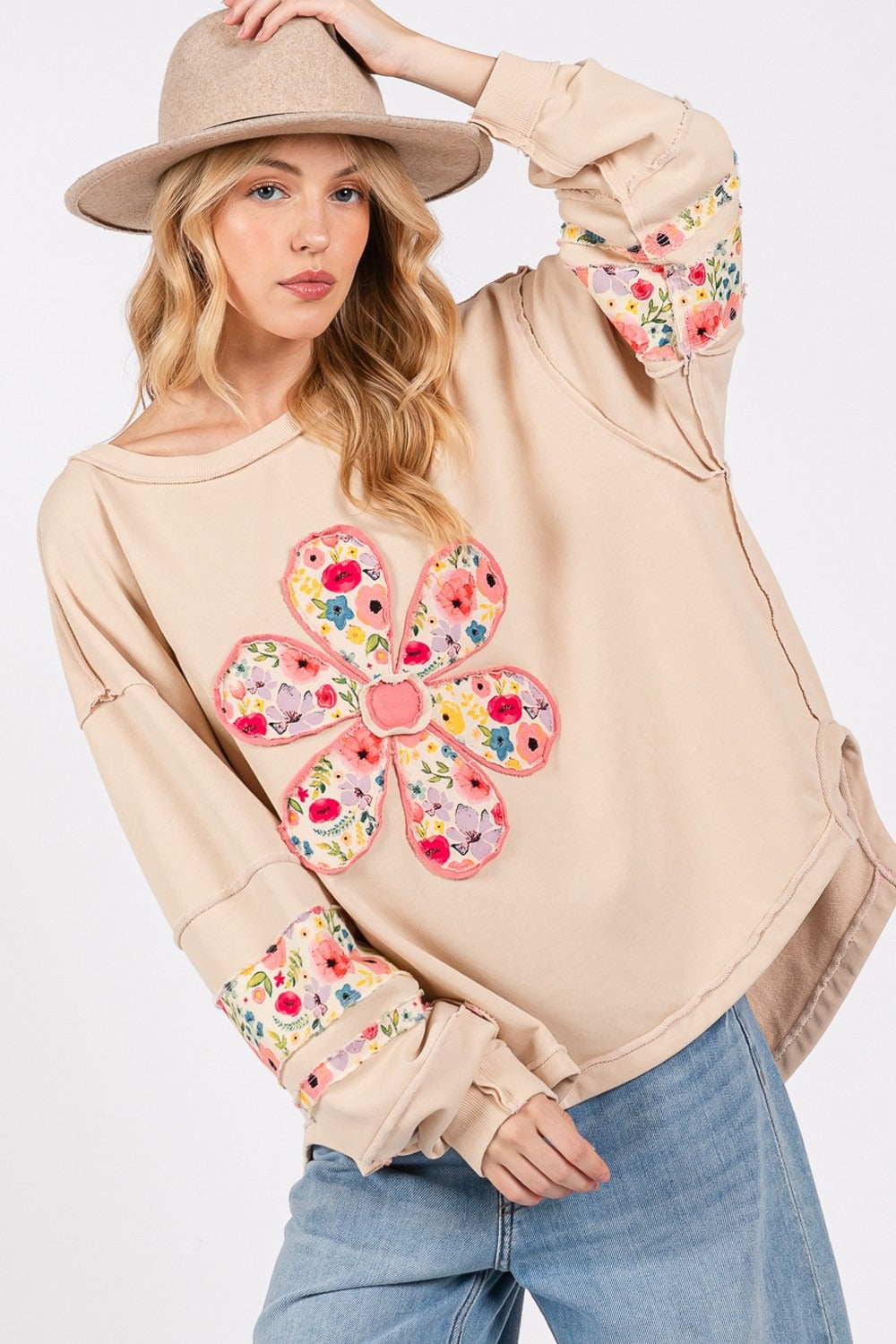 Woman wearing a Daisy Patch Applique Long Sleeve Sweatshirt with jeans and a hat.