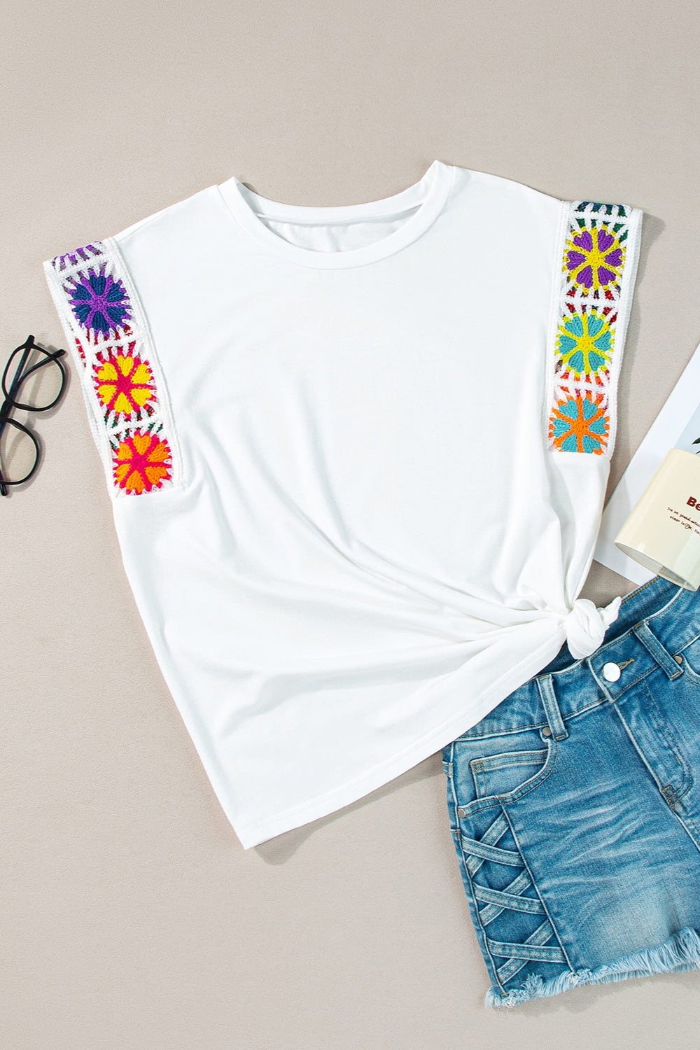 Boho colored cap sleeve top with multicolor embroidery detail, paired with denim shorts.