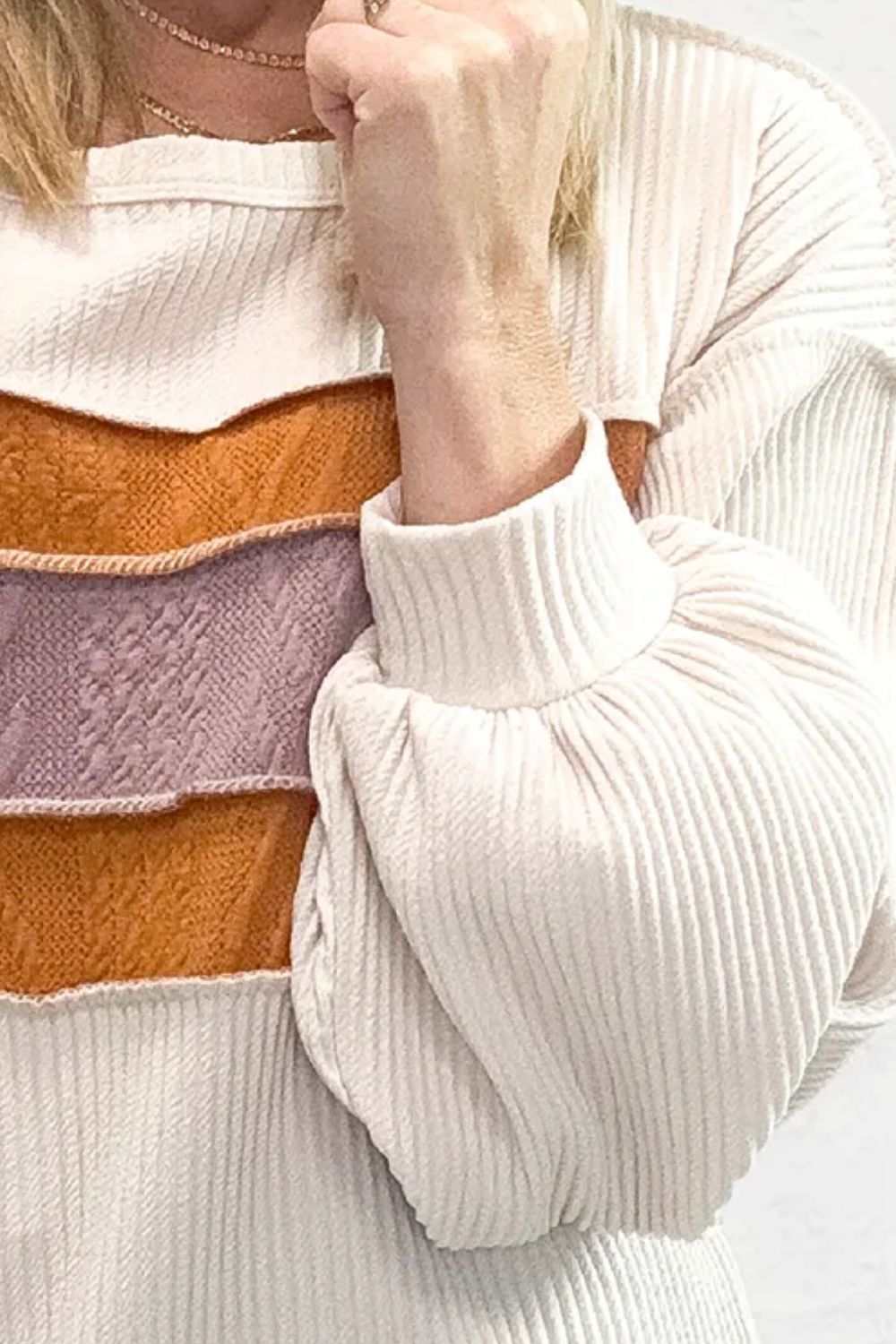 Color block long sleeve sweatshirt with ribbed texture and orange and pink panels.