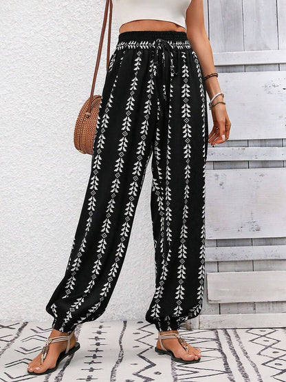 Tied printed high waist pants with black and white pattern, 100% polyester, adjustable tie waist.