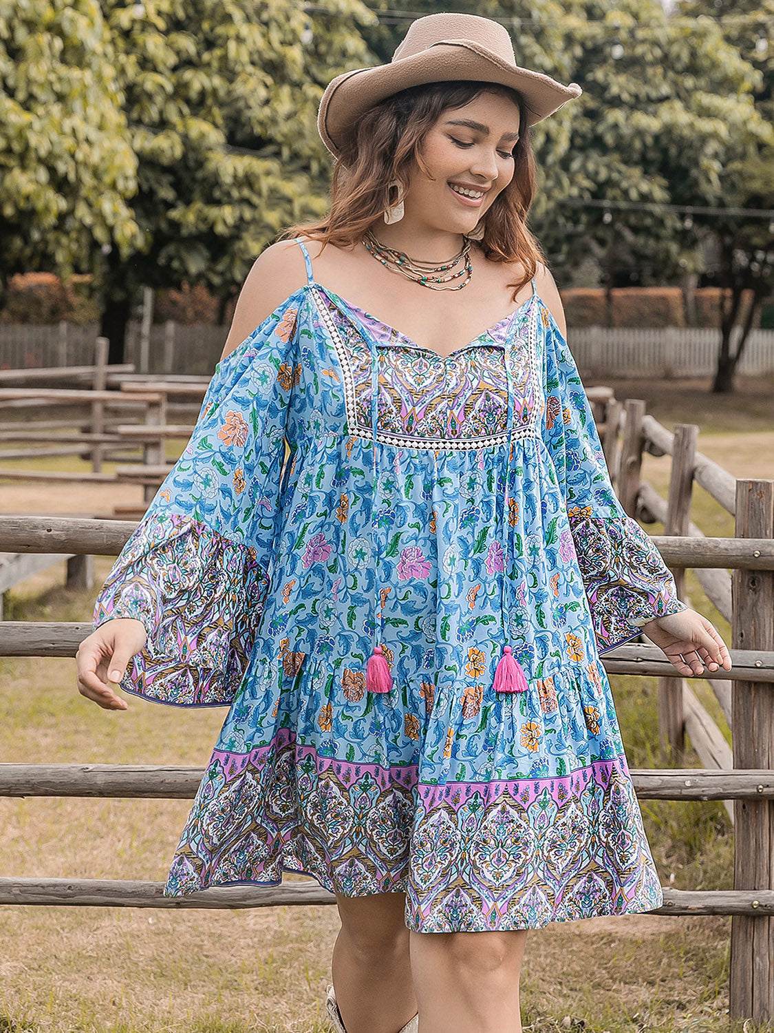 Plus size printed long sleeve mini dress in blue with floral patterns.