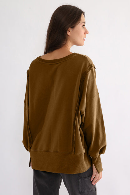 Exposed seam high-low long sleeve sweatshirt in brown, featuring a slit design and slightly stretchy 100% cotton material.