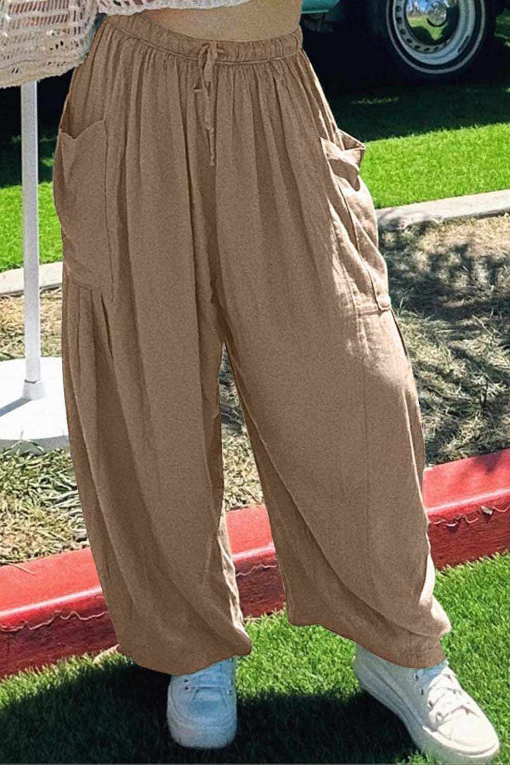 Boho wide leg harem pants with pockets in tan color, worn outdoors.