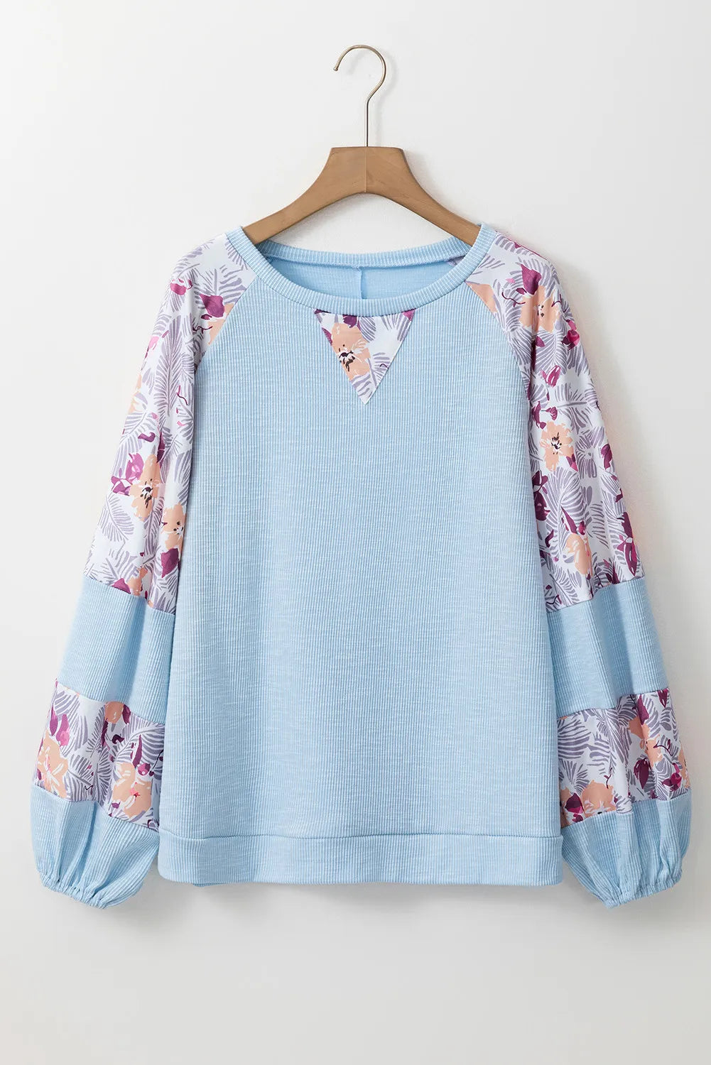 Printed round neck blouse with balloon sleeves, featuring a floral pattern on sleeves, basic style, slightly stretchy polyester-cotton blend.