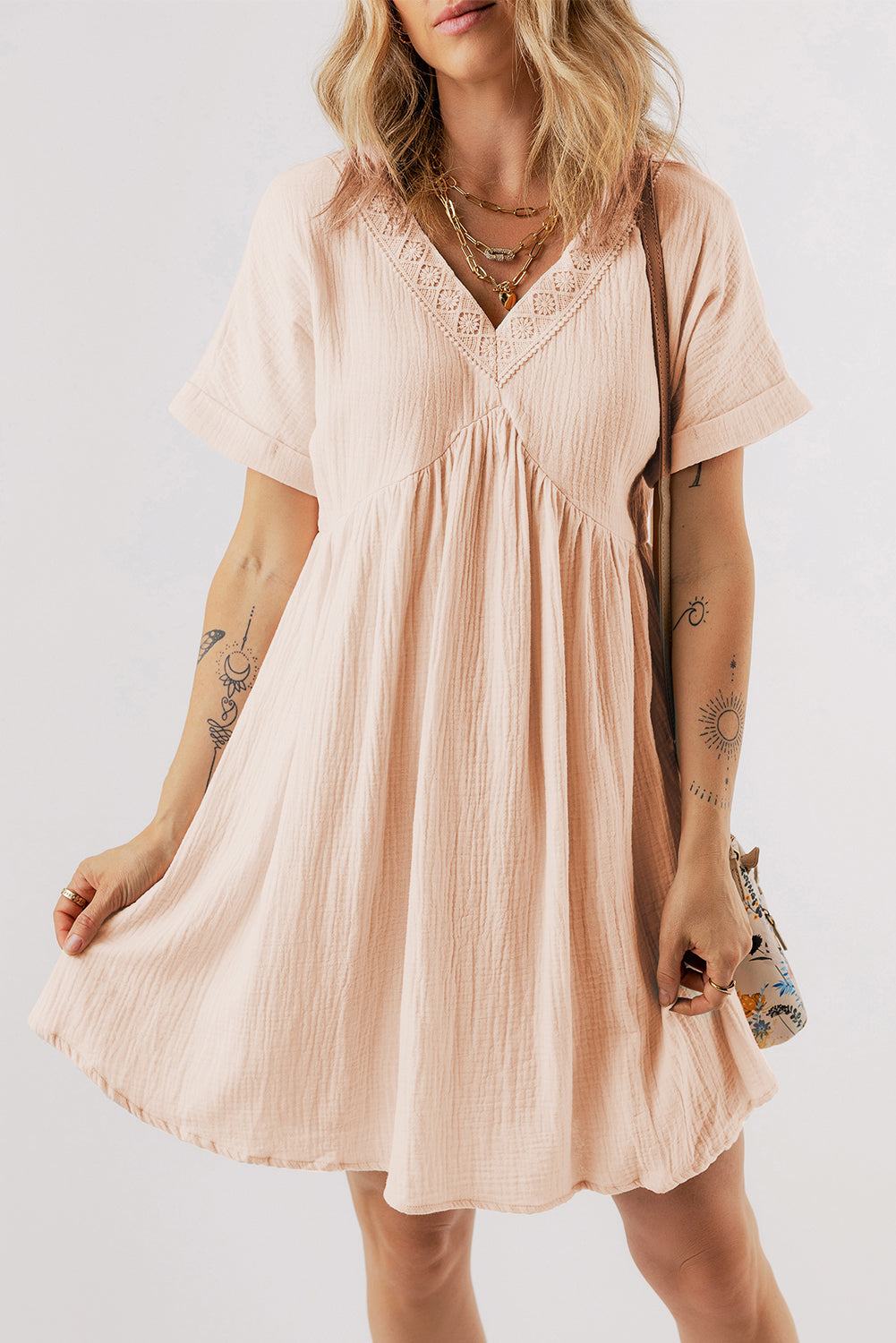 Beige mini dress with folded short sleeves, lace V-neck, and flared silhouette.