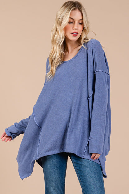 Oversized asymmetrical long sleeve top with drop sleeves and high-low hem in blue.