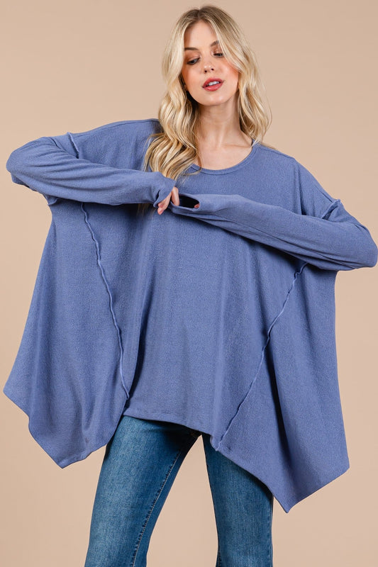 Oversized asymmetrical long sleeve top with drop sleeves and hi-low hem in blue.